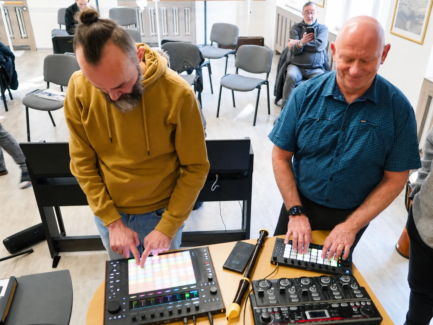 Učitel pracuje s tabletem, kytarou a looperem ve zkušebně
