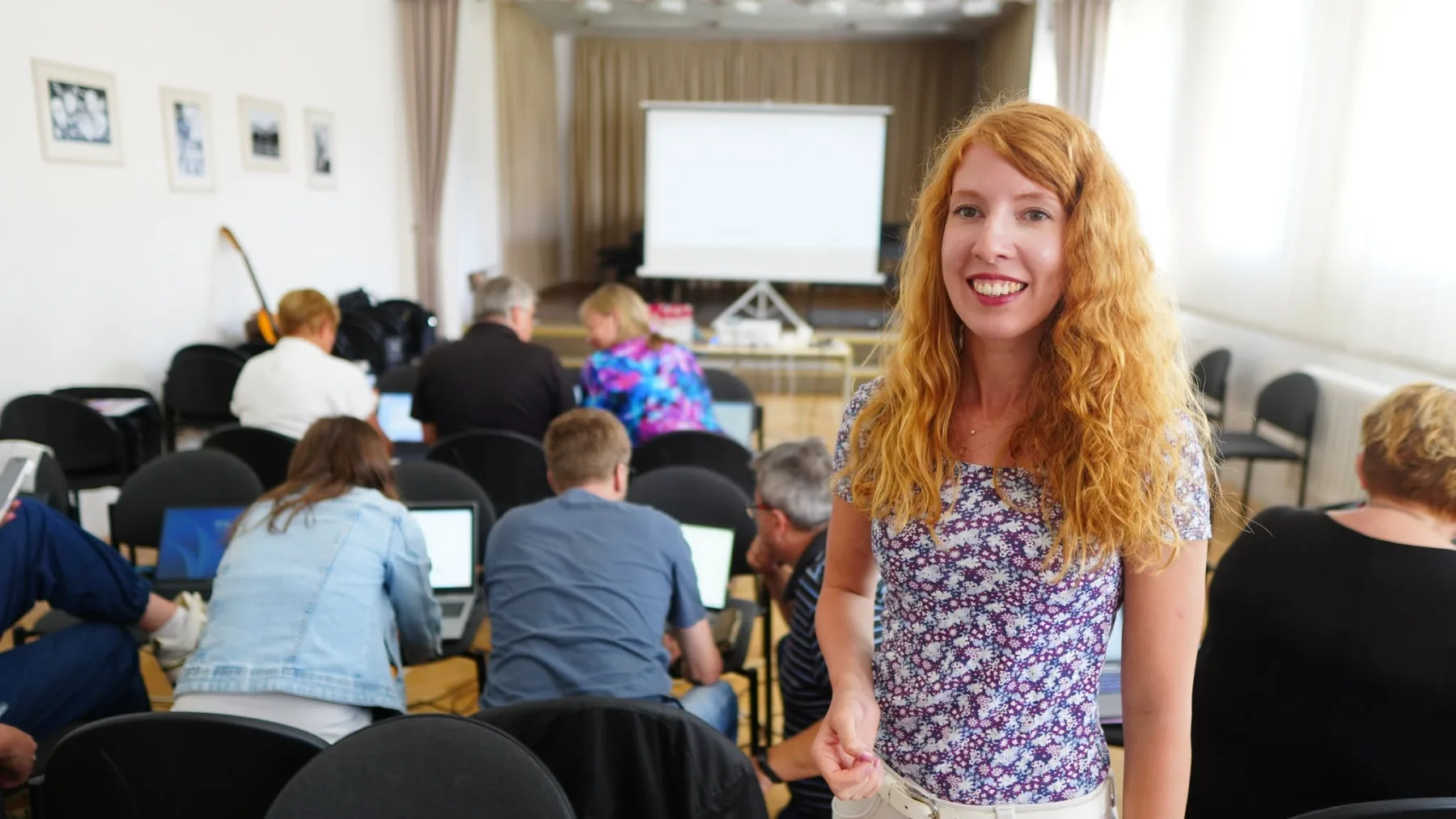 Skupina pedagogů společně pracuje s notovým materiálem u klavíru