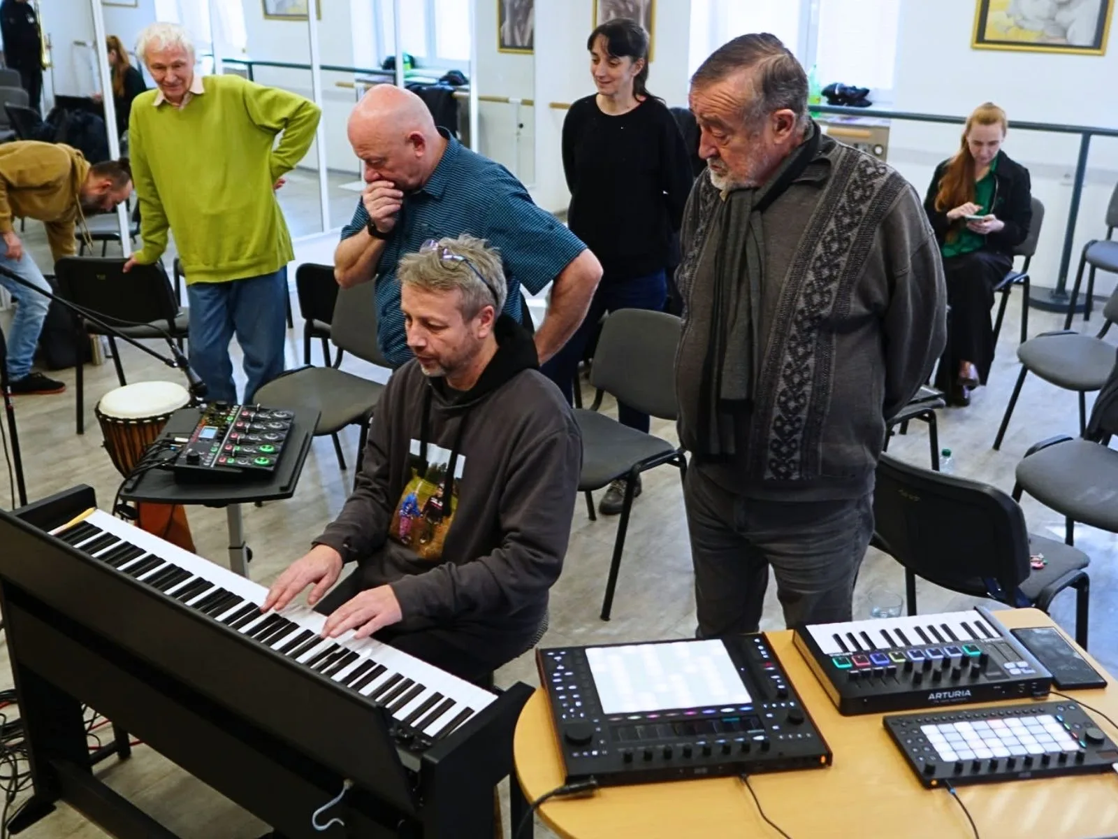 Učitel pracuje s tabletem, kytarou a looperem ve zkušebně